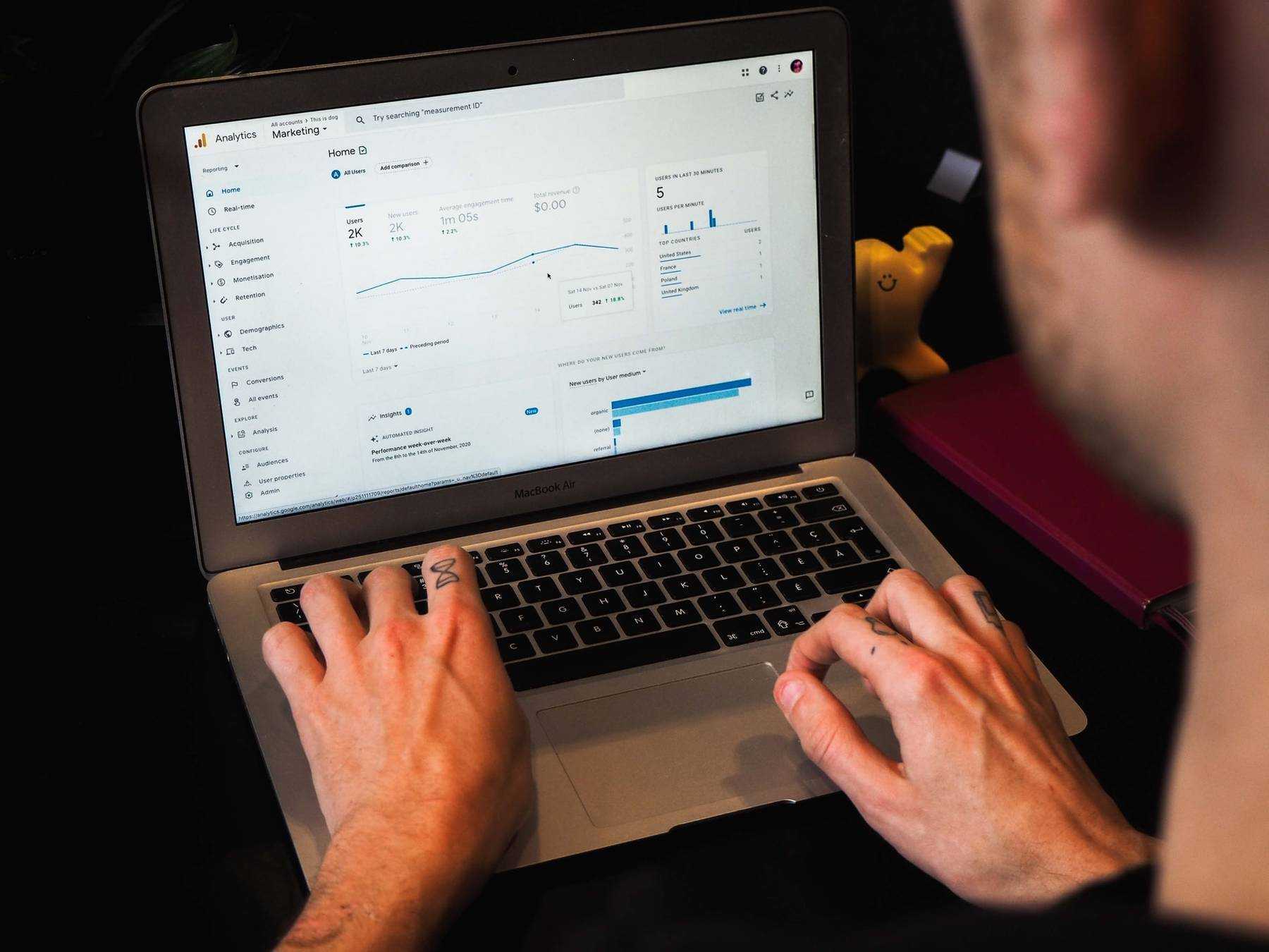 person using macbook pro on black table photo